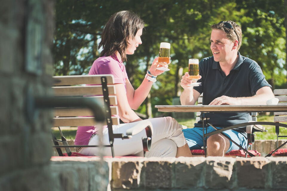 Dorfschänke, beer garden Paar sitzt im Biergarten der Dorfschänke und stößt mit einem Bier an